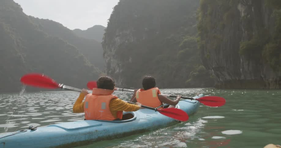 Two women paddle a boat