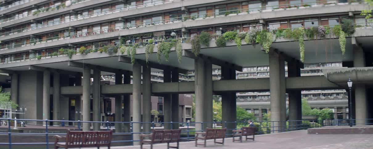 Benches line a sidewalk in a city near a large building