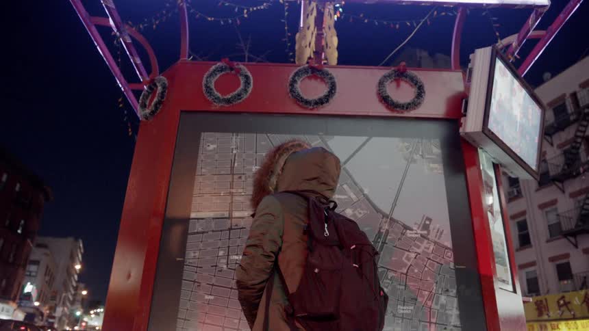 The person looks at the map display in the city