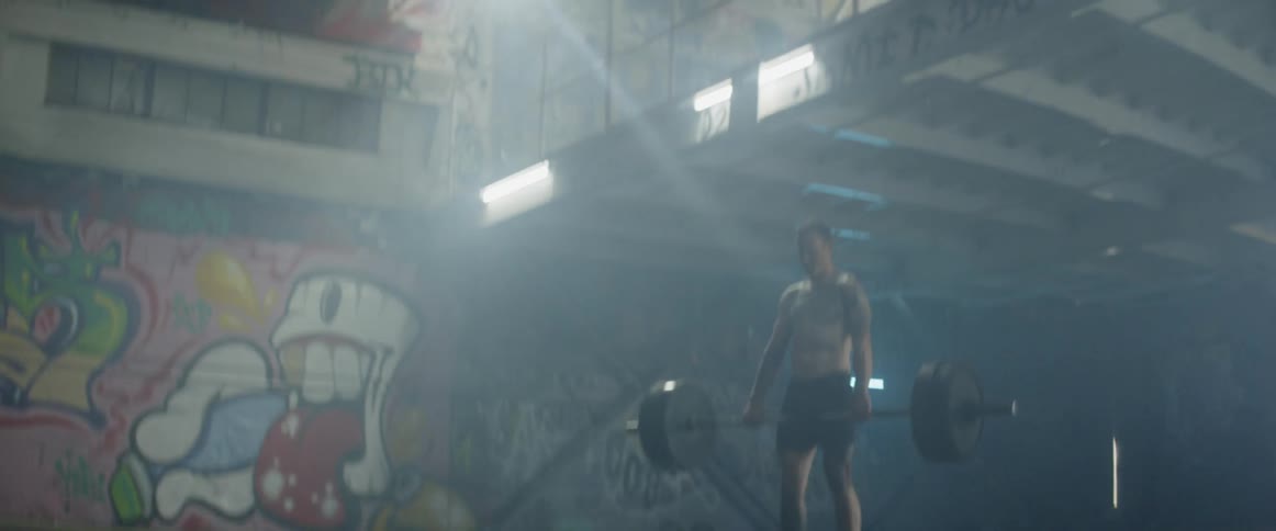 A man lifts weights in a gym