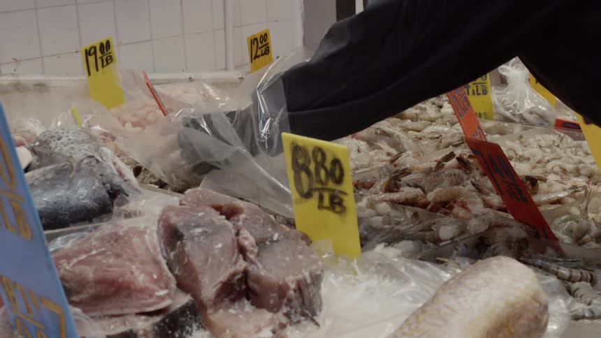 Man rummages through meat on ice