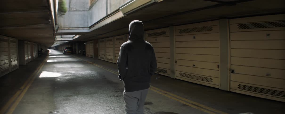 A man walks down the alley on a sunny day