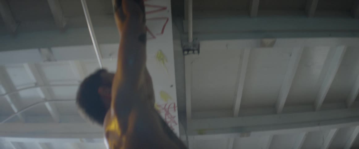 Man does pull ups on ceiling rafters