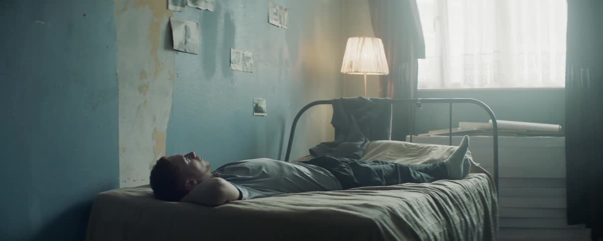 A man lays on a bed