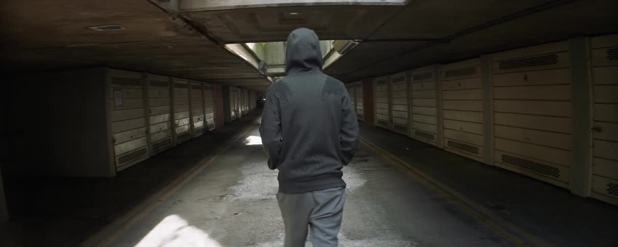 A person walks on the road under the overpass