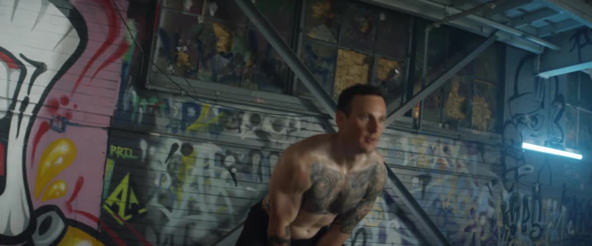 A man leans forward exercising with a kettlebell