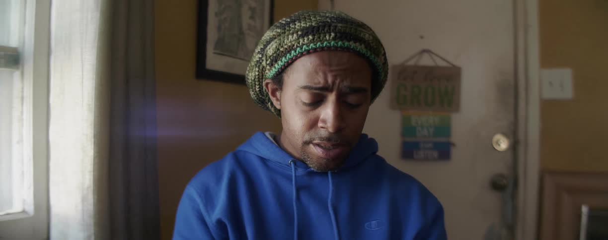 A sad man sings while sitting indoors