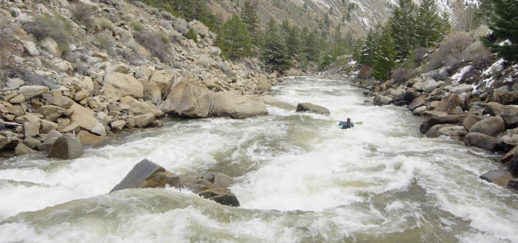 A canoe is paddled down the stream