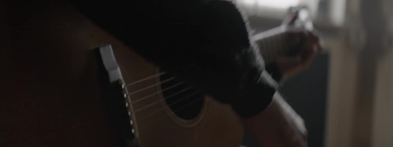 A man strums on a guitar