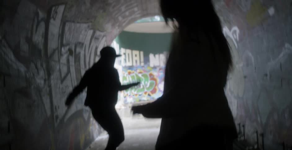 Two women dance inside a tunnel