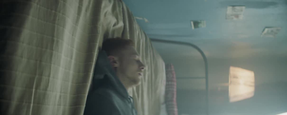 Man lies back on a bed