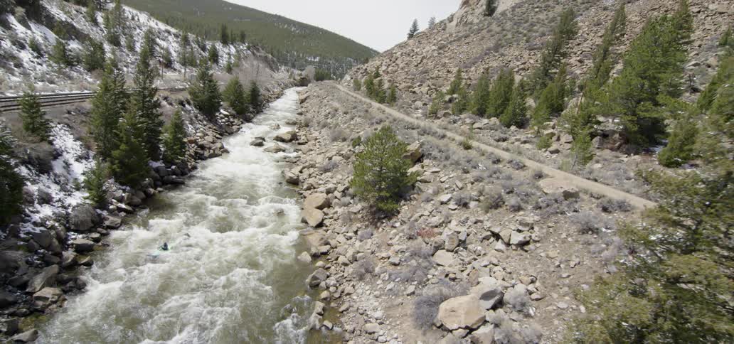 A person kayaks over river rapids