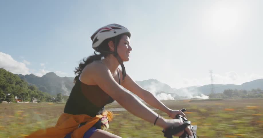 A woman is riding her bike on a sunny day