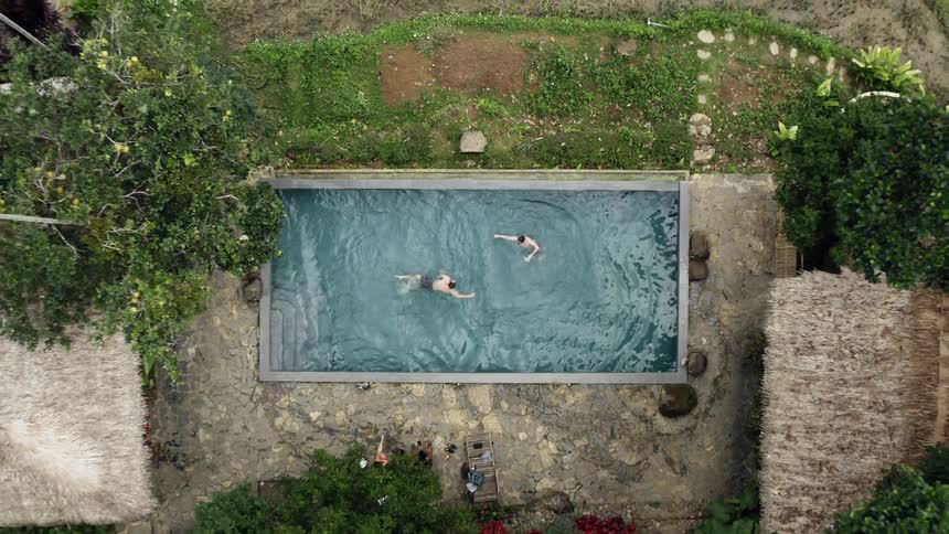Two boys jumping into a pool