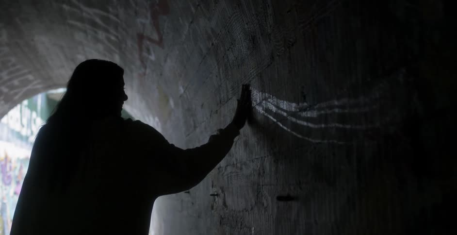 Woman rubs her hand on a tunnel wall