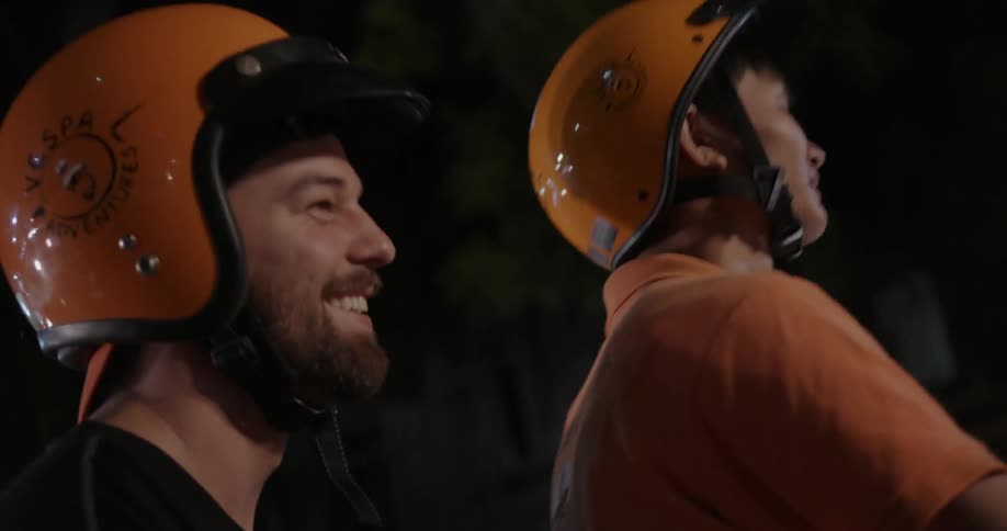 Man smiles while riding on a scooter