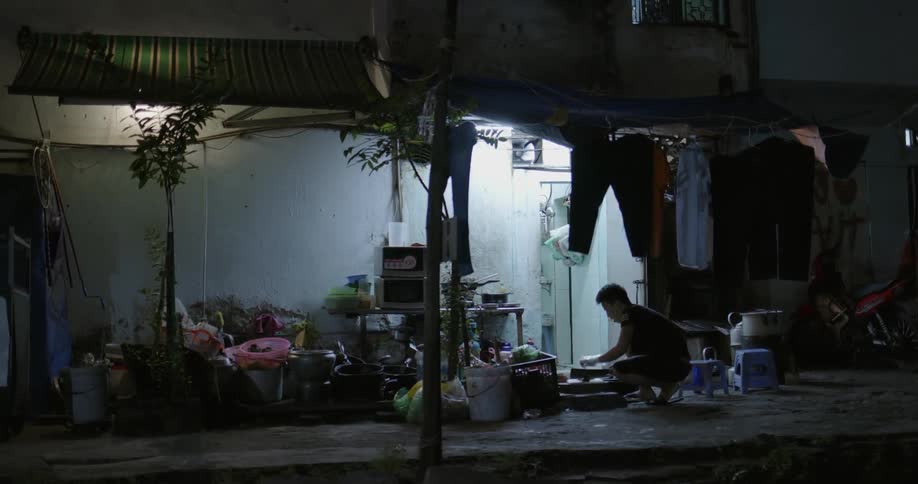 Man working at night outside small dwelling