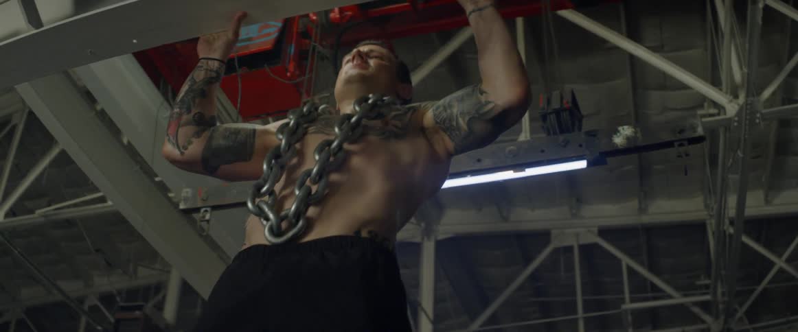 Man does pull ups on a ceiling beam