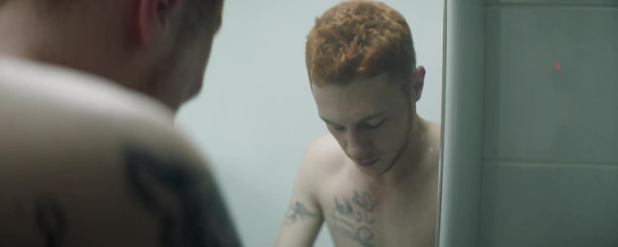 A man looks into the mirror in his bathroom