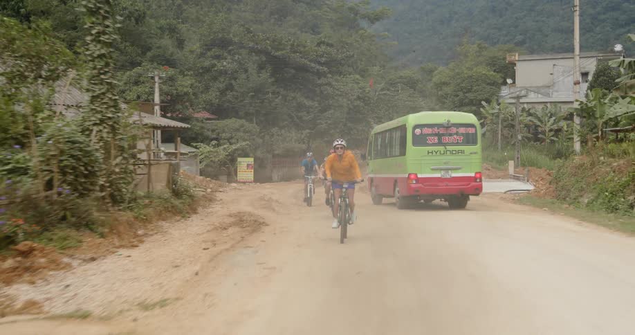 Bicyclists ride on a dirt road