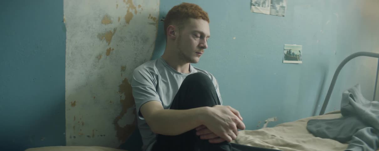 A man leans against the wall sitting in bed