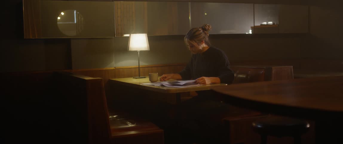 A woman looks around before going back to reading her newspaper