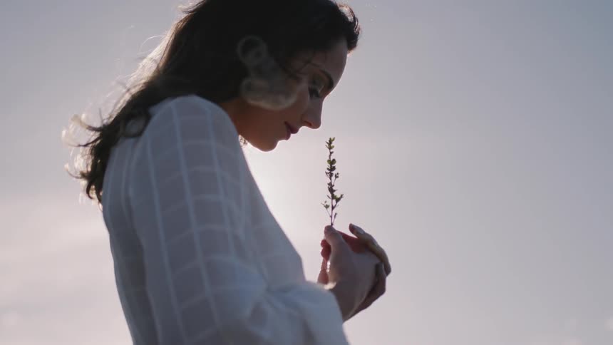 A woman smells a flower