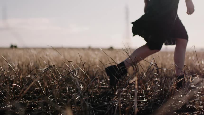 A woman walks through the tall grass