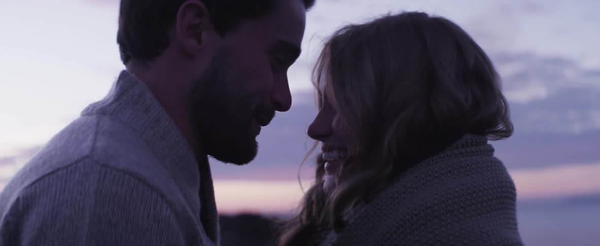 Man and woman hugging, talking, laughing and smiling on a chilly evening