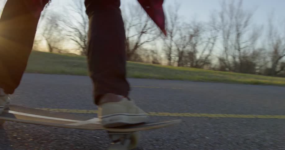 Person skates on a country road at sunset