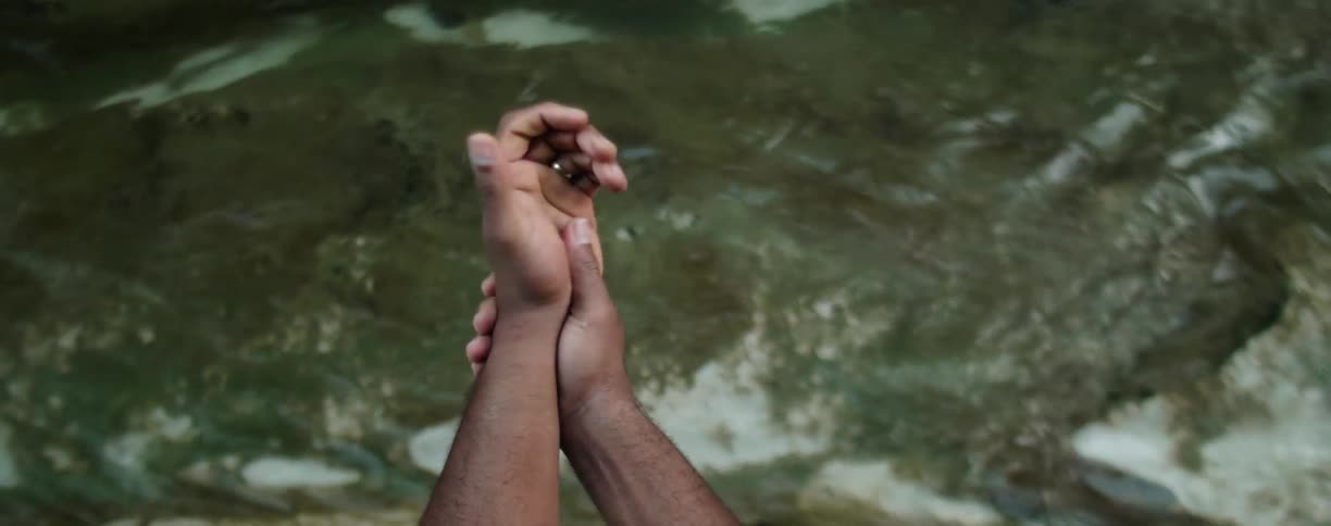 Man rubs his wrists over flowing water
