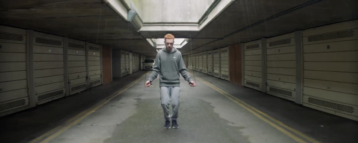 A man is jumping rope on the gravel