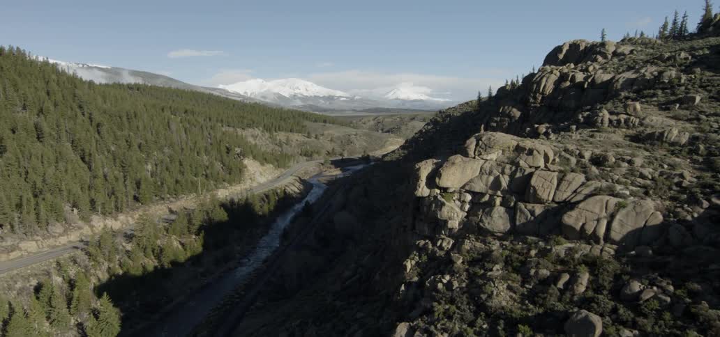 Steam flows through tree covered hills