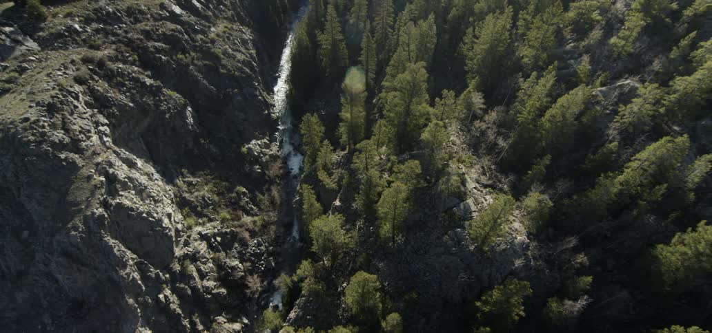 A stream travels the valley below a cliff