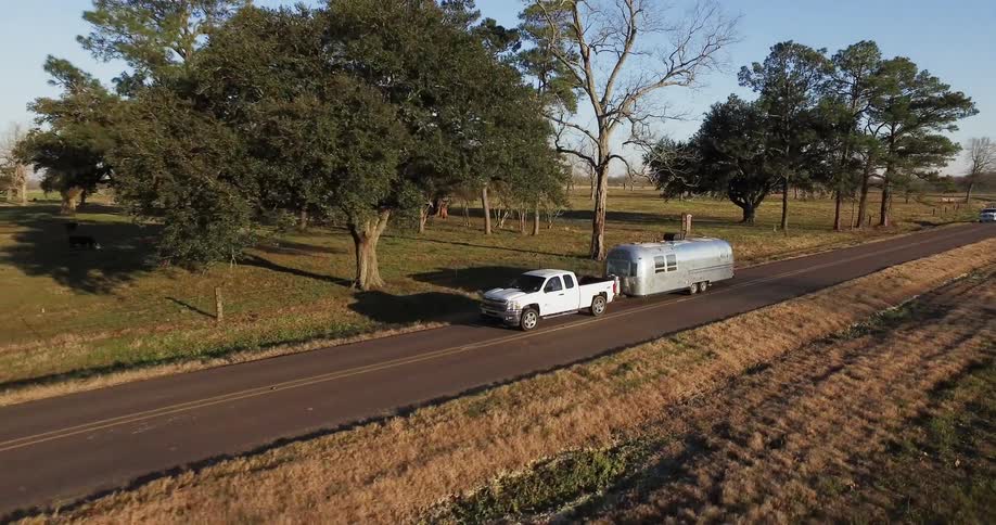 Truck pulls a trailer on a rural road