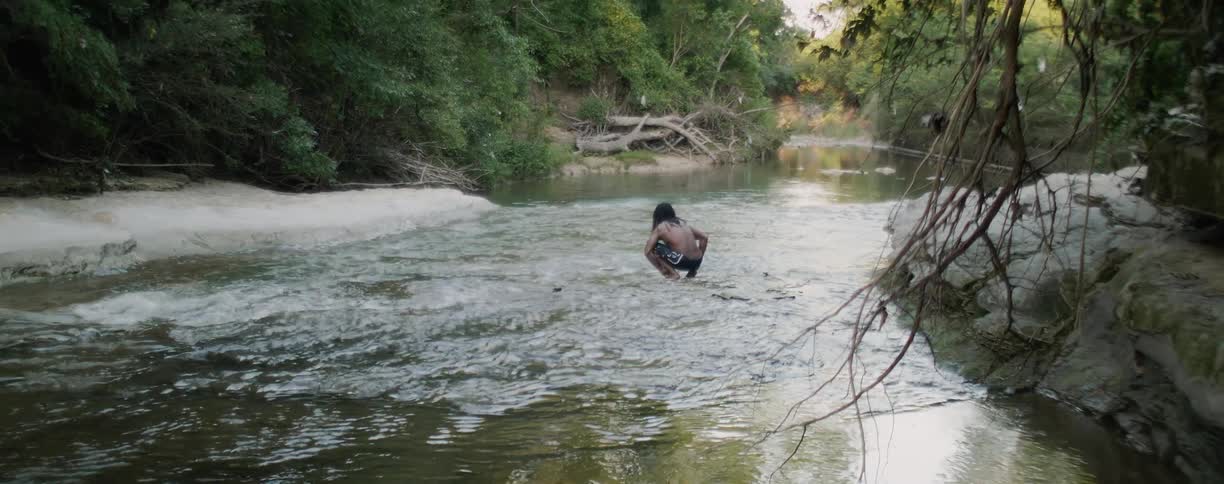 Man crouches in a river