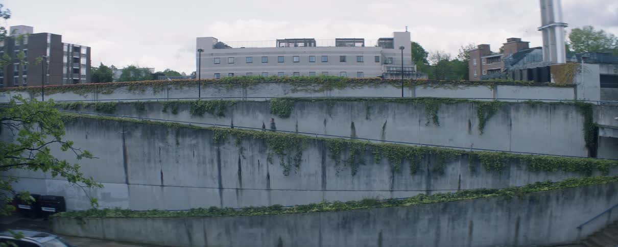 A man runs up a ramp towards buildings