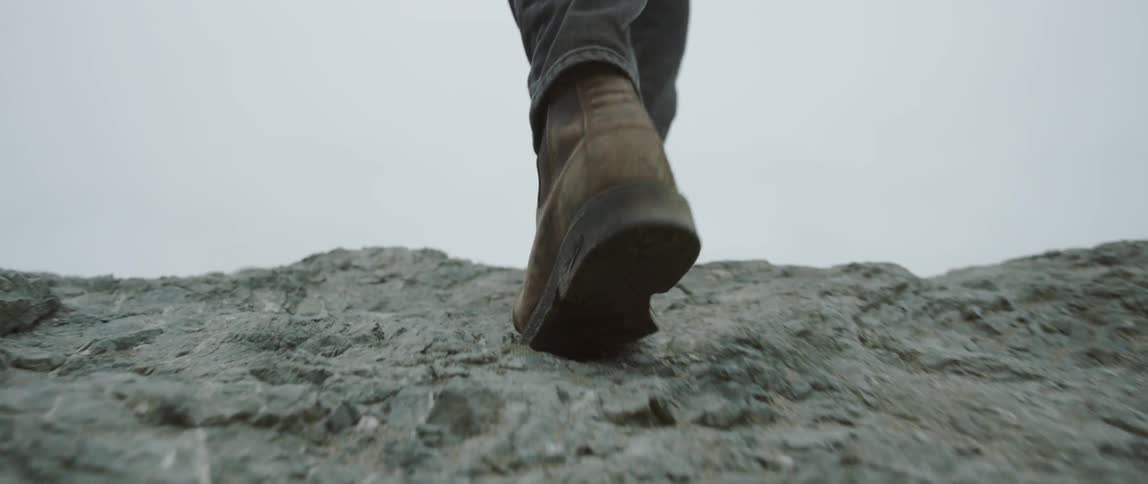 Person walks up a rock formation