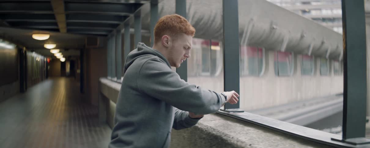 The man checks his watch and looks worried leaning forward