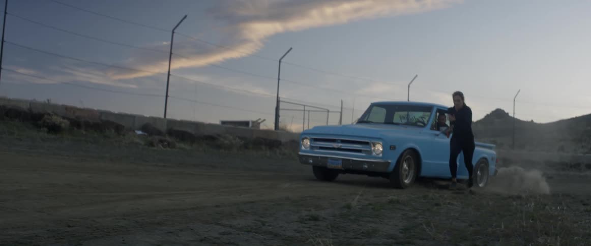 Woman runs next to an old pickup truck