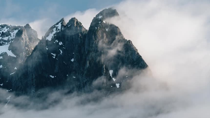 Clouds float around a mountain peak - 4K Time Lapse