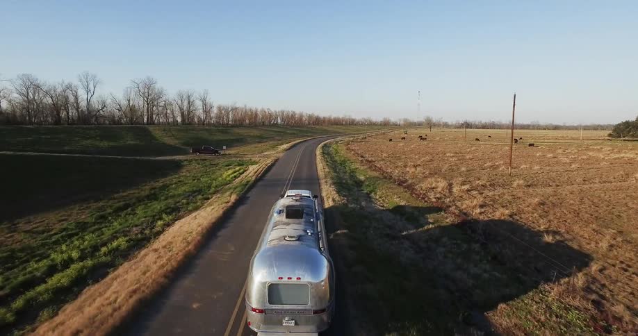 Truck pulling travel trailer is traveling on country highway