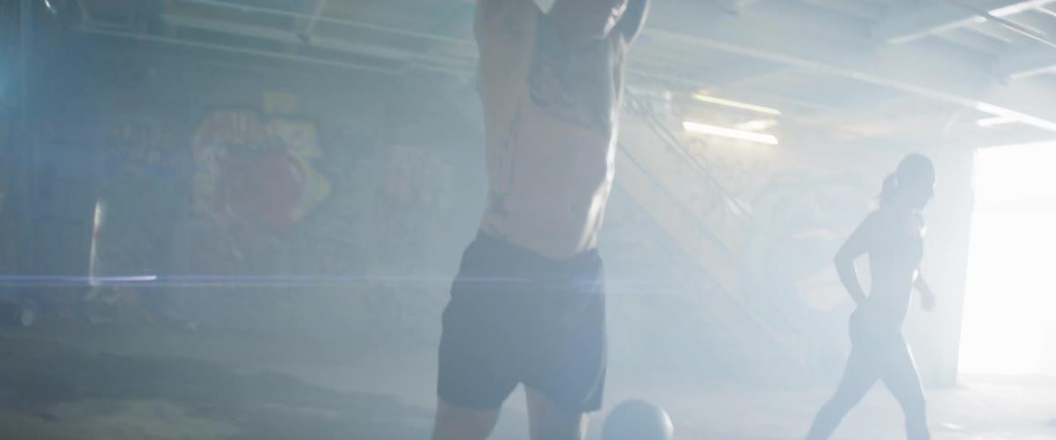 People exercise in a building with graffiti