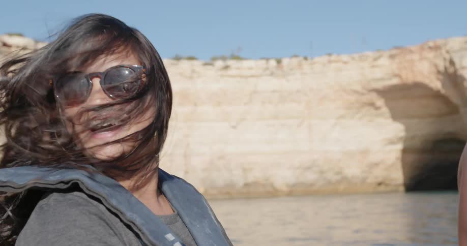 A woman laughs as she rides on the boat