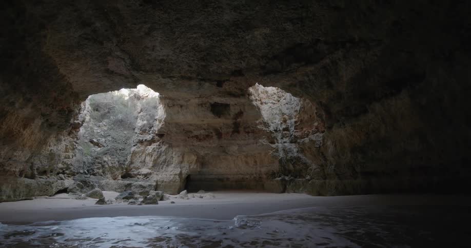 Ocean waves flow beneath a rock formation