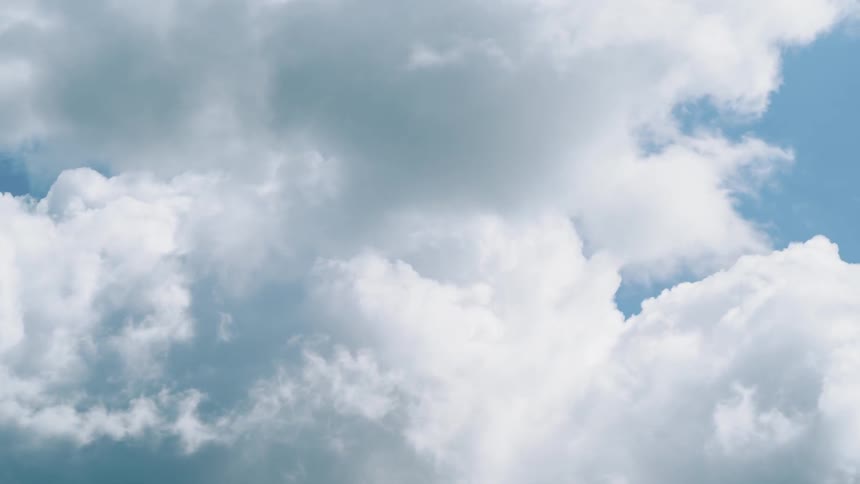 White clouds move across a blue sky