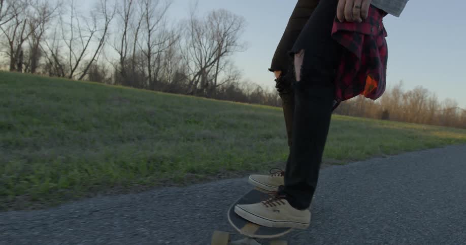 Man rides a skateboard down the road