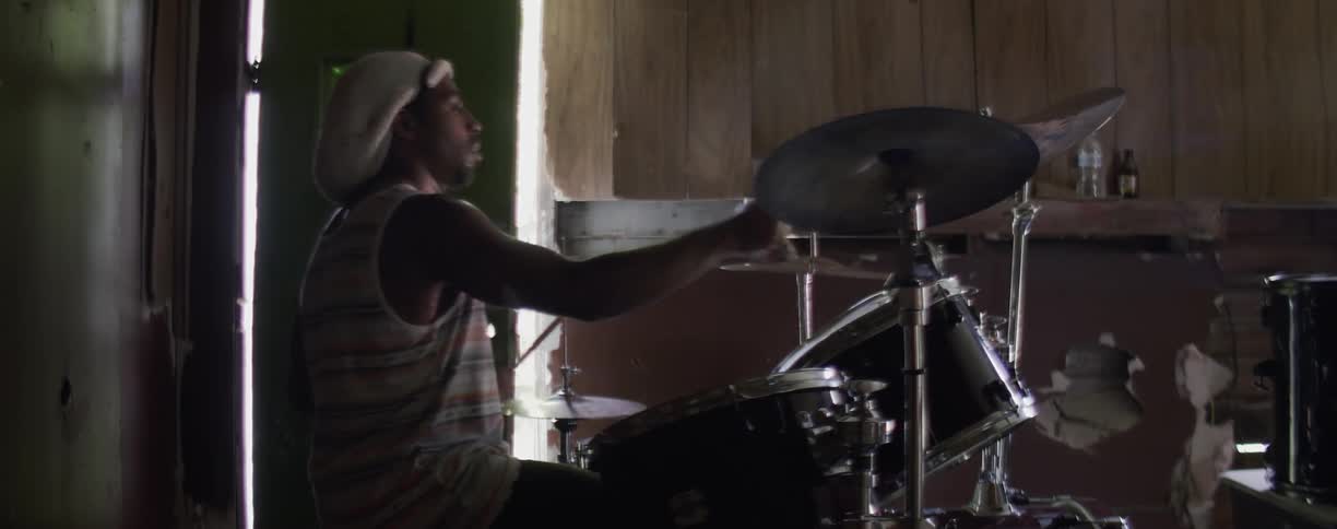 Man sits as he plays the drums