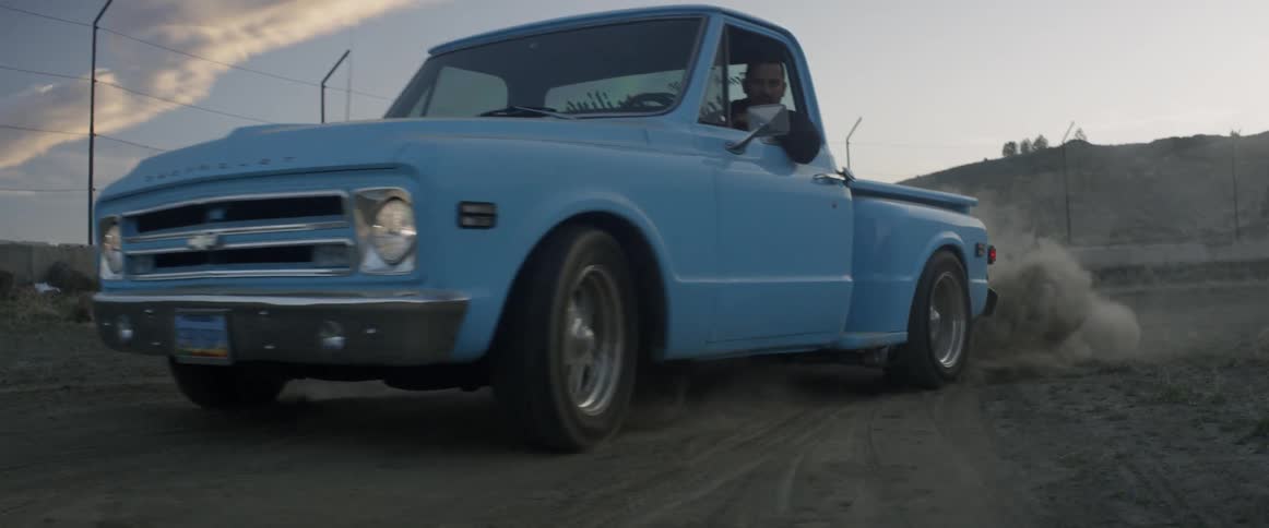 Blue truck takes off and leaves a puff of dust behind