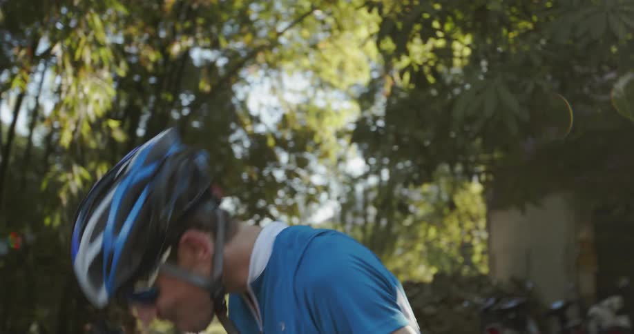 Man in a bike helmet drinks from a water bottle